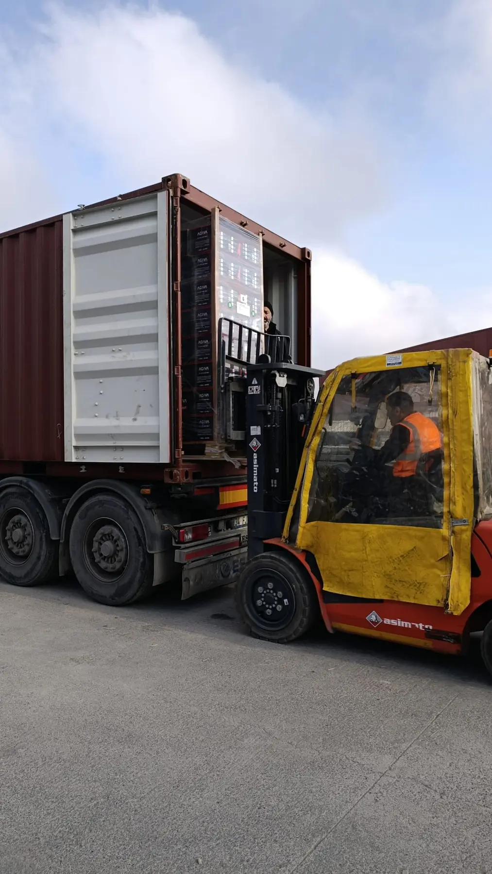 Export container being loaded by forklift